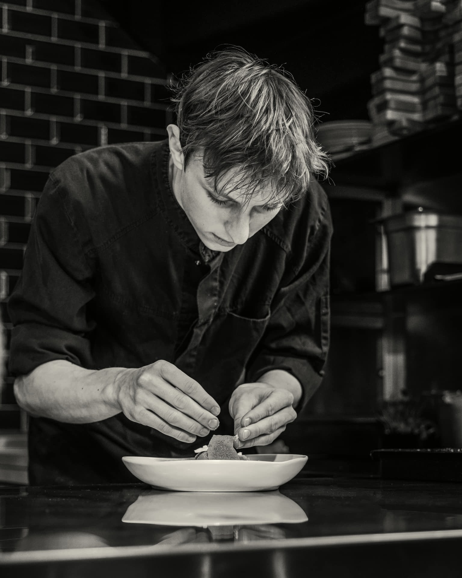 Kok van Ensemble Gastro & Bar in Zwolle die een gerecht met precisie opmaakt
