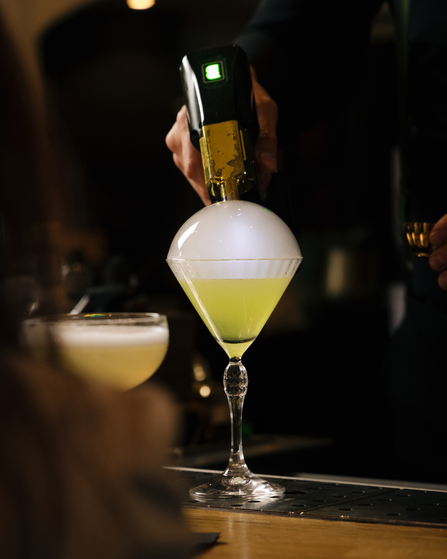 Bartender maakt een signature cocktail achter de bar van Ensemble Zwolle